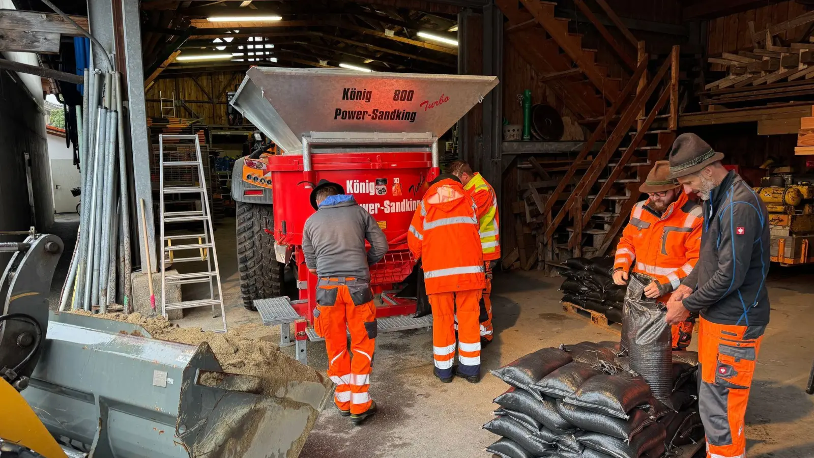 Der Regen drückt das Grundwasser derart nach oben, dass Einsatzkräfte Sandsäcke zum Schutz von Gebäuden oder Straßen befüllen müssen.  (Foto: Simon Frank/Gemeinde Aschau/dpa)