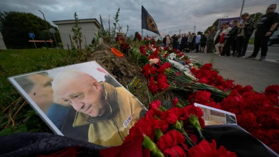 Ein Porträt des Chefs der Privatarmee Wagner, Jewgeni Prigoschin, liegt an einer informellen Gedenkstätte in St. Petersburg. (Foto: Dmitri Lovetsky/AP/dpa)