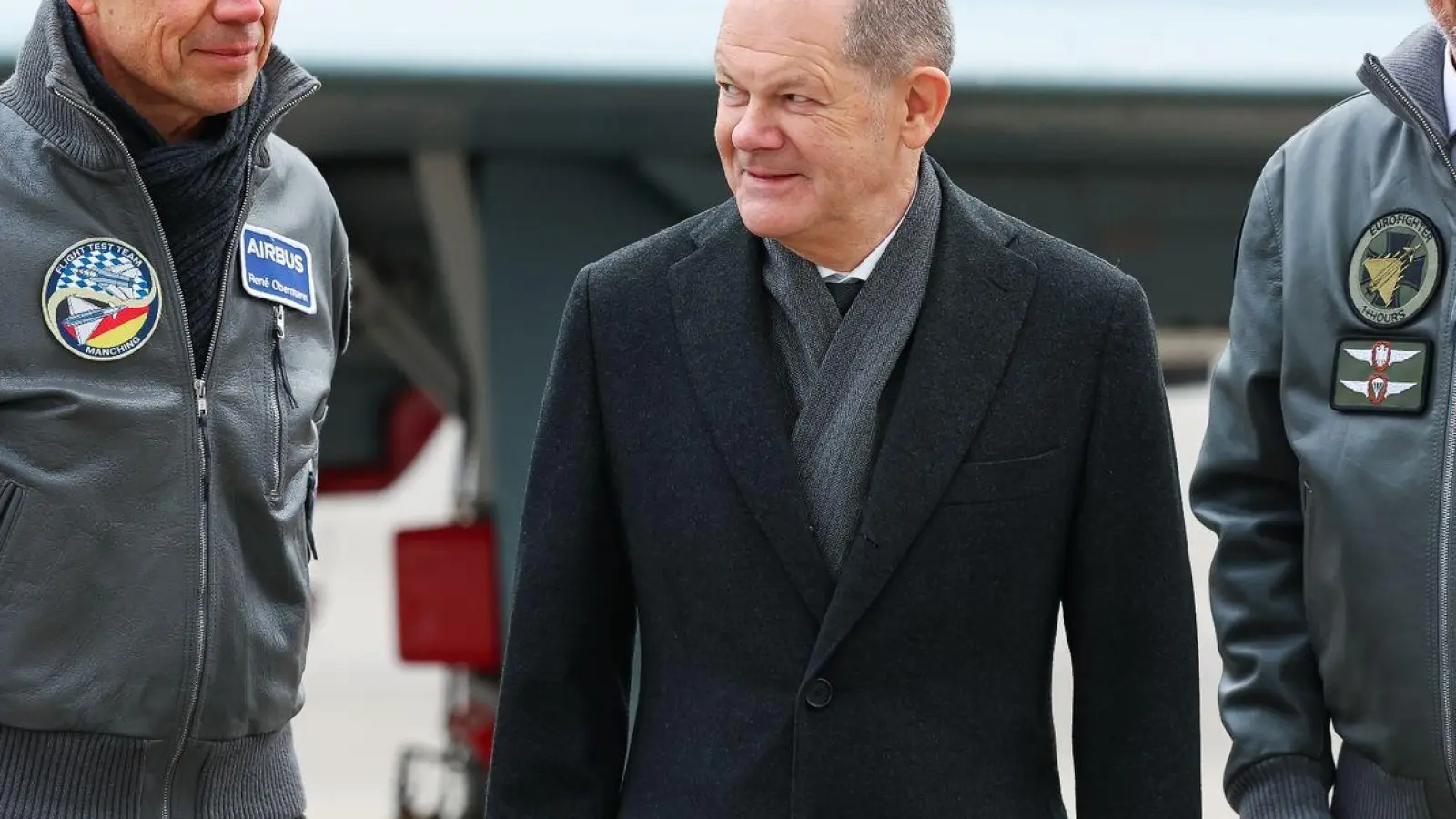 Bundeskanzler Olaf Scholz (SPD, M) besucht den Airbus-Militärstandort und steht mit Rene Obermann (l), Verwaltungsratsvorsitzende der Airbus SE und Mike Schöllhorn (r), CEO der Airbus Defence and Space. (Foto: Daniel Löb/dpa)