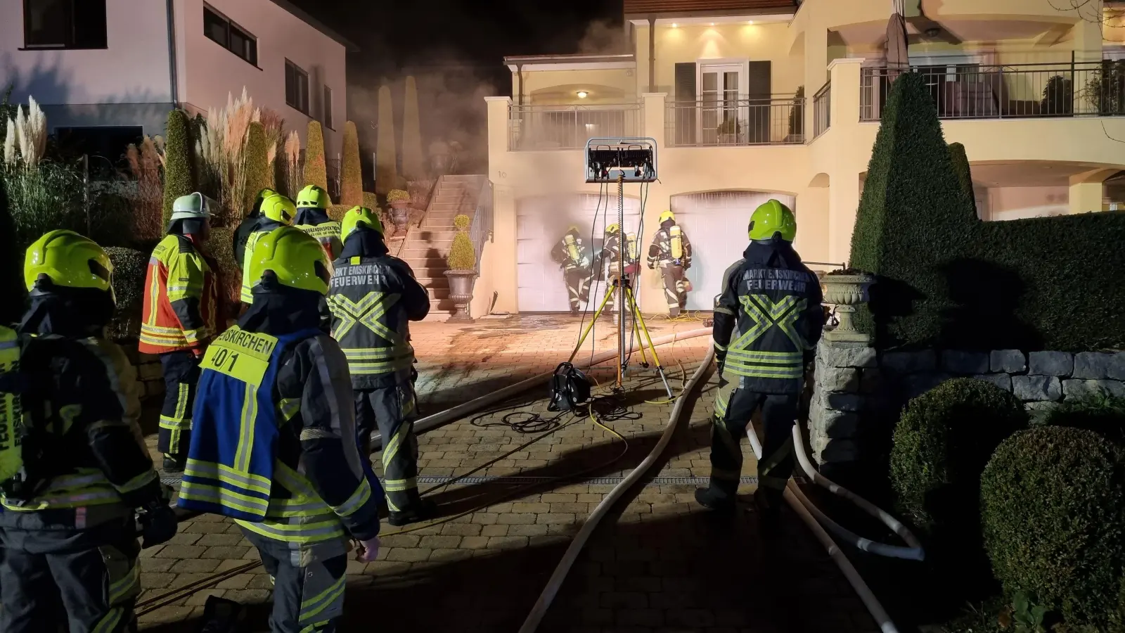 Mit einem Trennschleifer schnitten Kräfte der Emskirchener Feuerwehr eine Öffnung in ein Garagentor, damit der Rauch abziehen kann. (Foto: Rainer Weiskirchen)