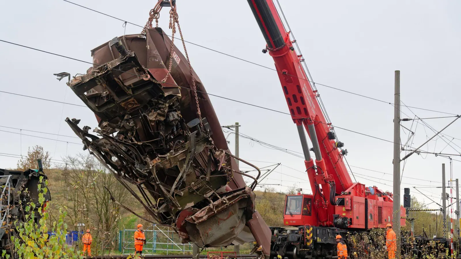 Ein schwerer Kran hob einen ersten Güterwaggon von den Gleisen und stellte ihn neben den Schienen ab. (Foto: Henning Kaiser/dpa)