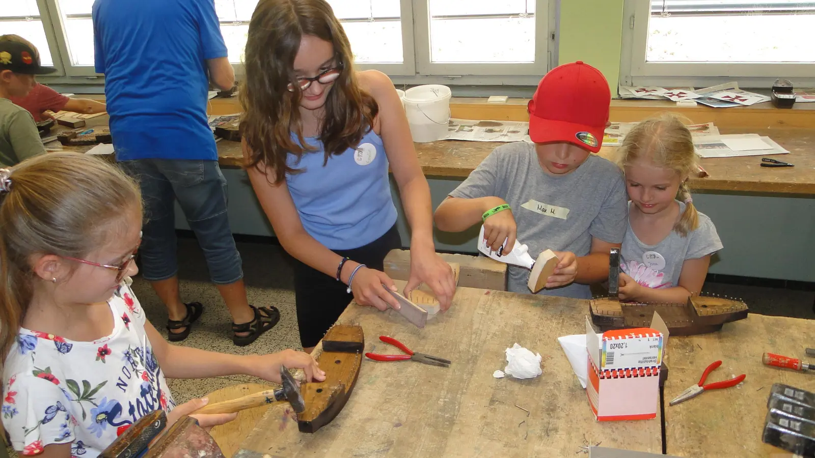 Lenja (9), Emelie (12), Maximilian (8) und Jana (6) sind im Werkraum der Waldschule mit Feuereifer dabei, ein Piratenschiff aus Holz zu basteln. (Foto: Winfried Vennemann)