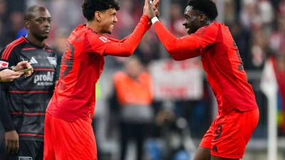 Der große Moment für Adam Aznou (l): Der 18 Jahre alte Debütant wird für Alphonso Davies (r) eingewechselt, der sich mit ihm freut. (Foto: Tom Weller/dpa)