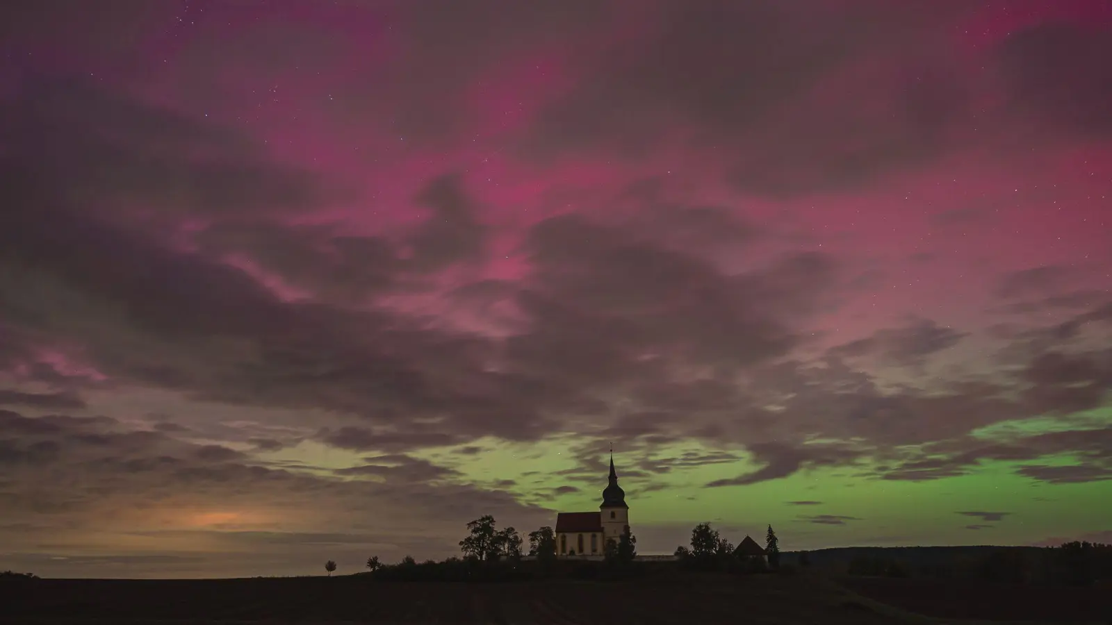 Über der Bergkirche St. Michael im Ipsheimer Ortsteil Kaubenheim schimmerten die Polarlichter in bunten Farben. (Foto: Mirko Fryska)