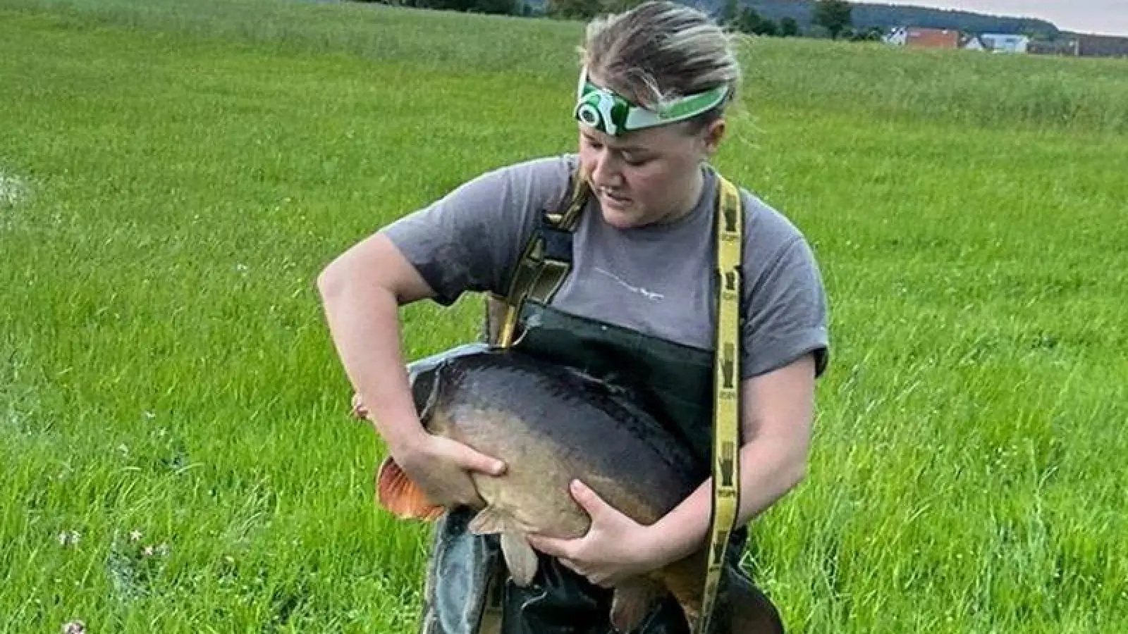 Lola Eyrisch mit einem der unzähligen Karpfen, die aus der Wiese gerettet werden konnten. (Foto: privat)