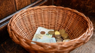 Ein Korb mit Geldscheinen und Münzen steht in einer Kirche. (Foto: Elisabeth Edich/dpa/Archivbild)