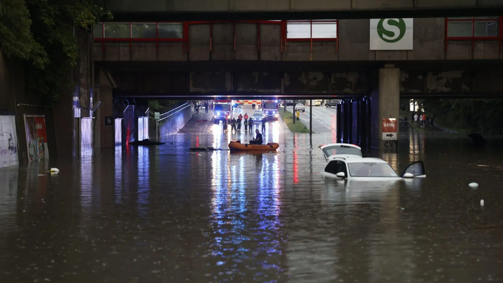 Einsatzkräfte der Feuerwehr können nur noch mit einem Schlauchboot zu den Autos in einer überschwemmten Unterführung gelangen. (Foto: Oßwald/News5 /dpa)