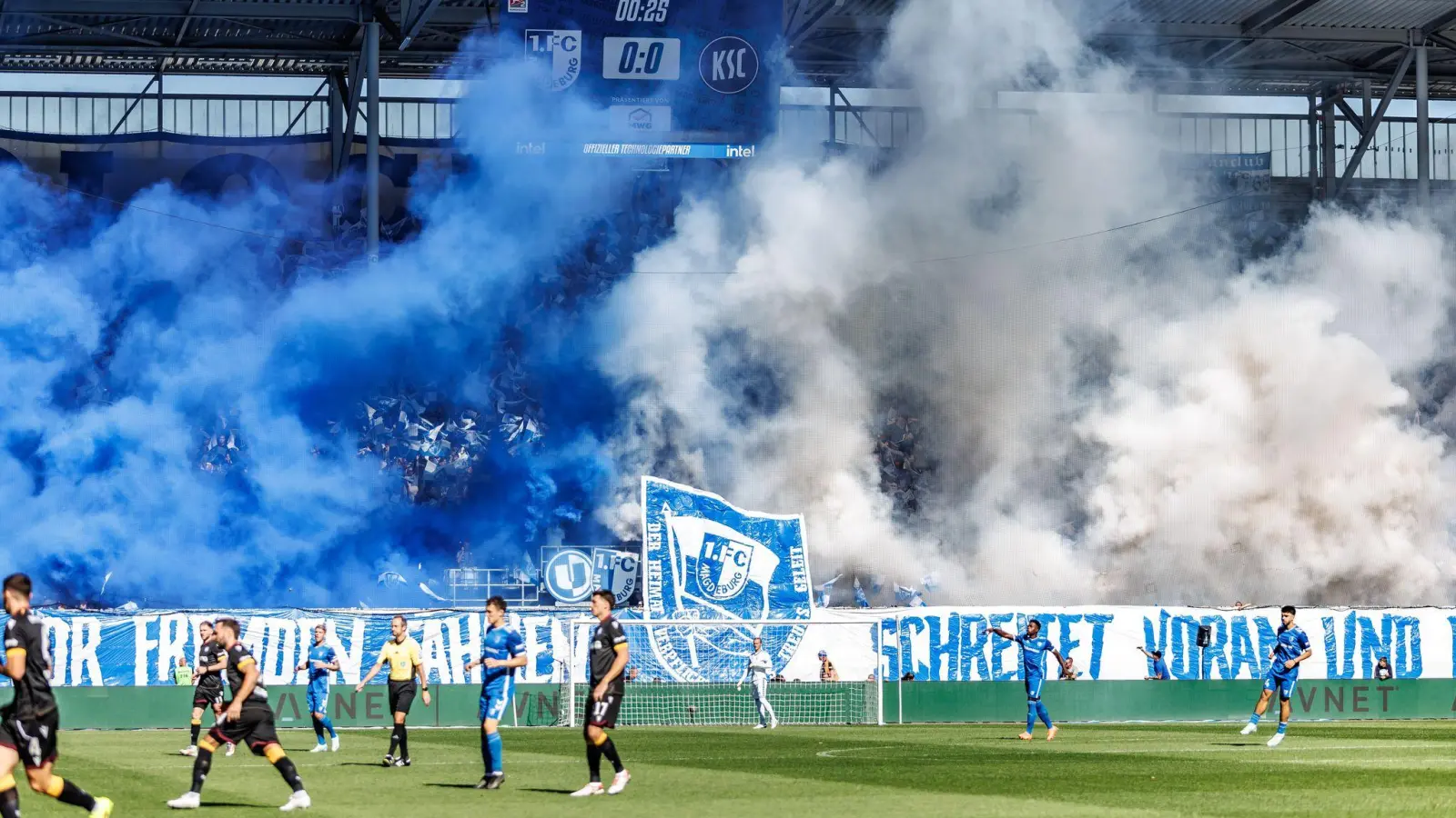 Die Magdeburger Fans zeigen ein fragwürdiges Banner und betonen dies mit Pyrotechnik. (Foto: Andreas Gora/dpa)