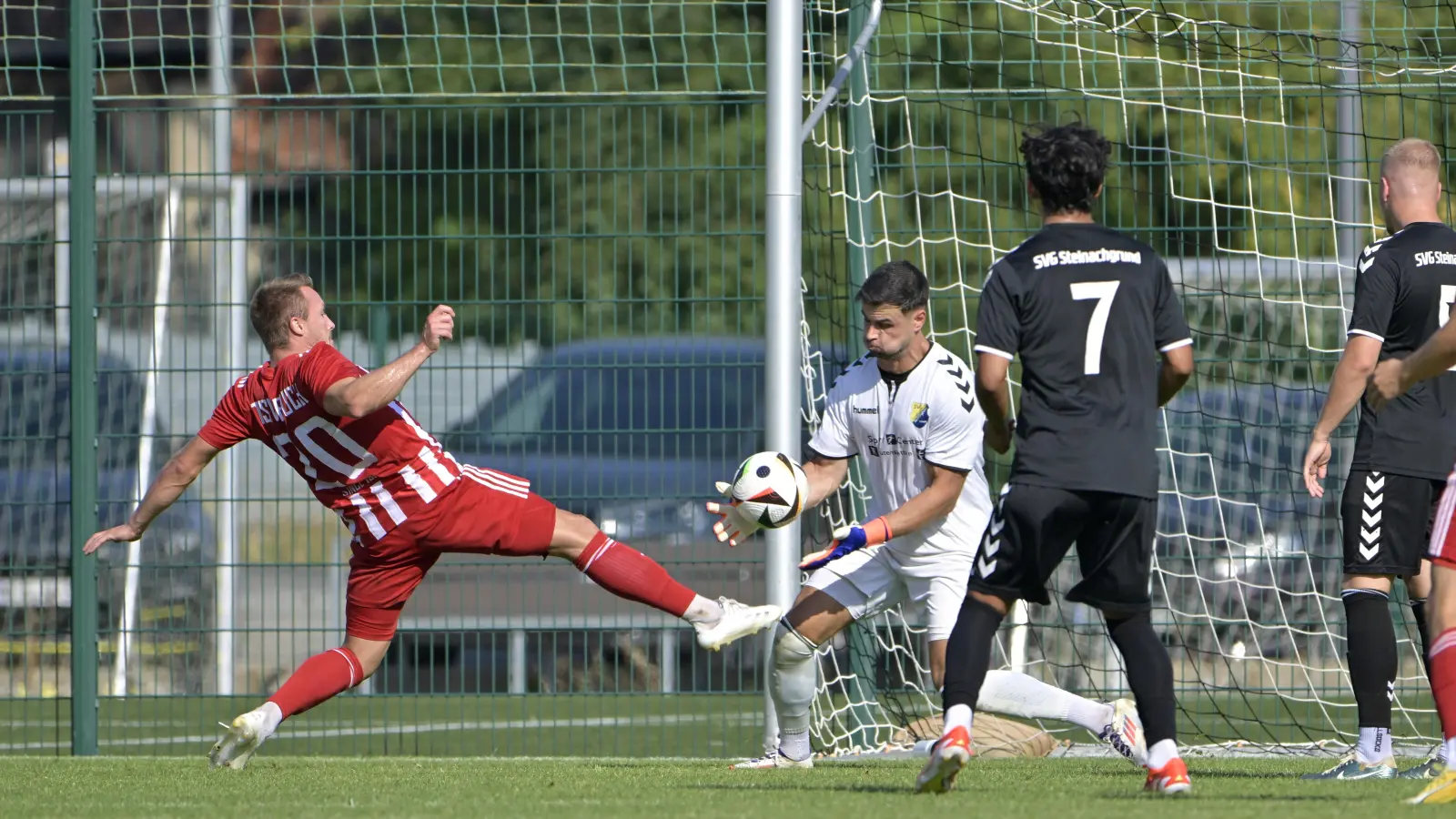 Da bläst Steinachgrunds Torwart Daniel Himmrich die Backen ganz dicke auf, den Ball fängt er trotzdem ganz locker vor dem Bucher Jens Wartenfelser (links) ab, beobachtet von SVG-Spieler Giancarlo Ramirez (Nr. 7). Die Landesliga-Partie gewann Gastgeber Steinachgrund mit 4:2. (Foto: Martin Rügner)