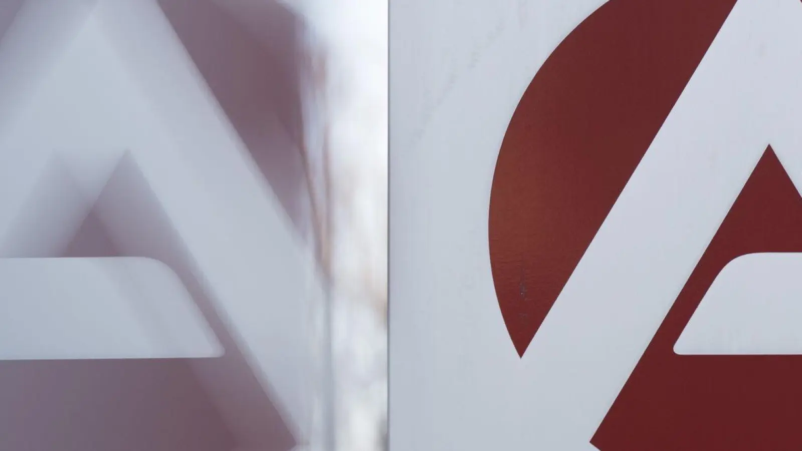 Das Logo der Bundesagentur für Arbeit spiegelt sich in einer Scheibe. (Foto: Sebastian Kahnert/dpa)