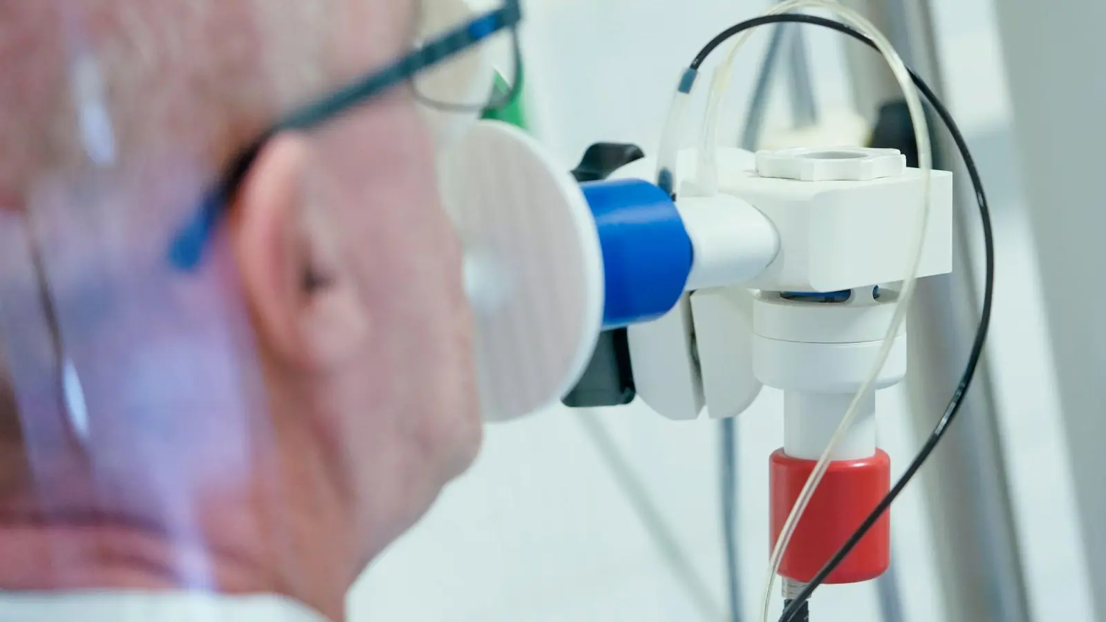 Ein von einer Corona-Erkrankung genesener Patient bekommt in einer Lungentest-Kabine in einer Rehaklinik die Lungenfunktion gemessen. (Foto: Uwe Anspach/dpa)