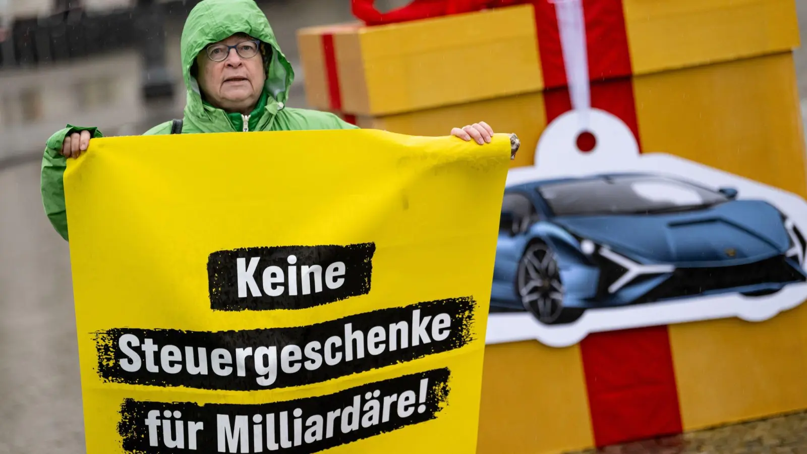 Eine Greenpeace-Aktivistin auf einem Protest für eine Milliardärssteuer am Brandenburger Tor. (Foto: Fabian Sommer/dpa)