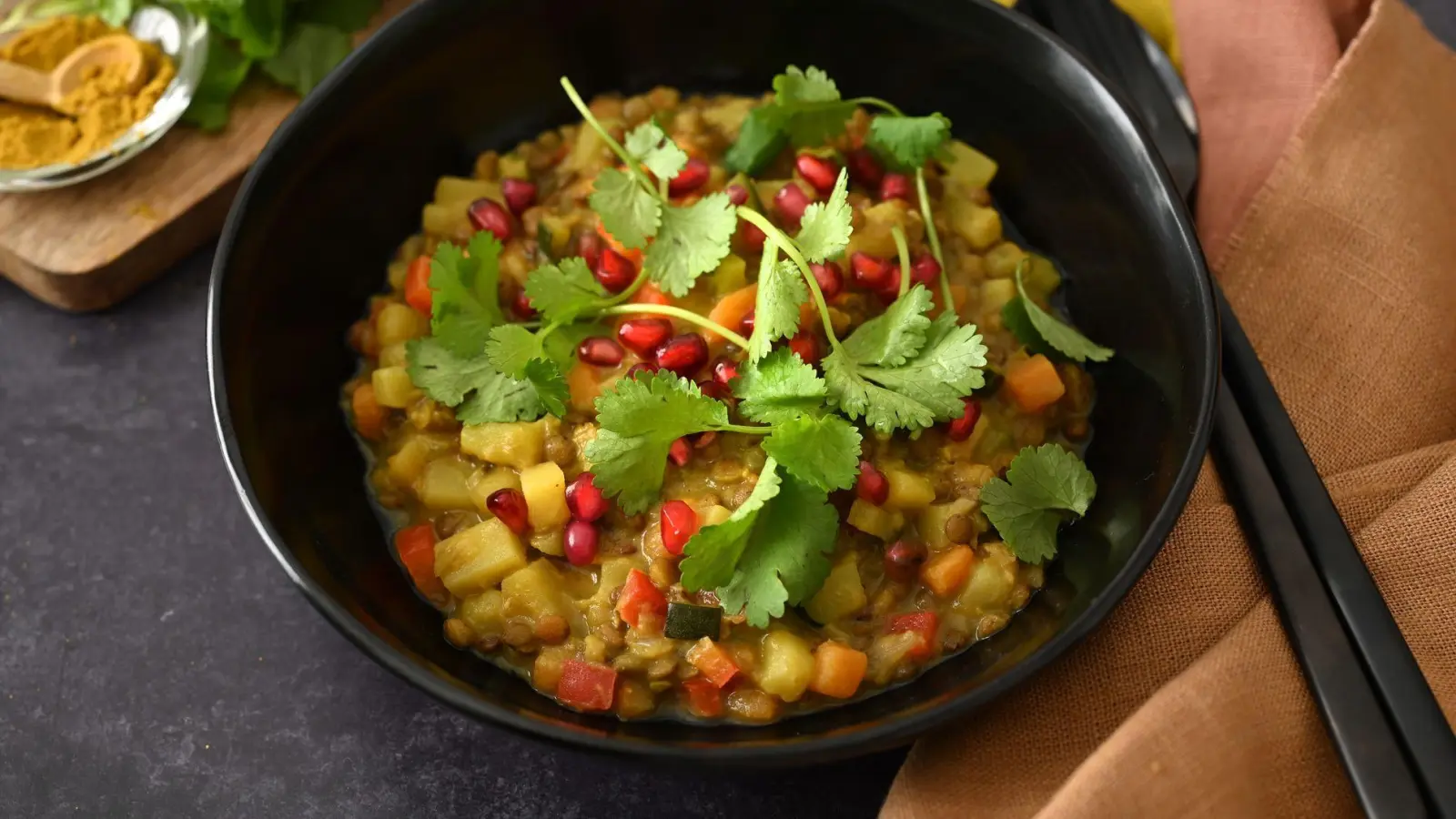 Frische Korianderblätter und Granatapfelkerne lassen hier im ersten Moment einen Salat vermuten. Doch die beiden Zutaten sind das Topping für den exotischen Linseneintopf. (Foto: Julia Uehren/loeffelgenuss.de/dpa-tmn)