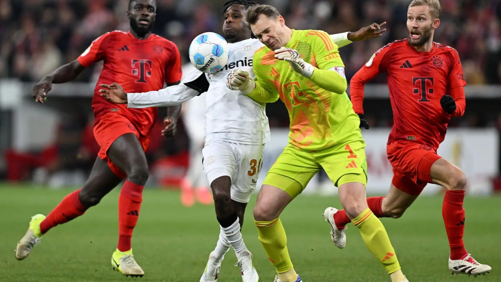 Manuel Neuer kommt zu spät und rammt Leverkusens Jeremie Frimpong um. (Foto: Sven Hoppe/dpa)