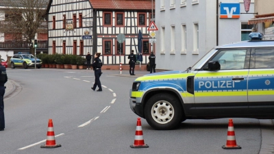 Polizeibeamte sichern die Straße rund um die Bankfiliale. (Foto: René Priebe/PR-Video/dpa)