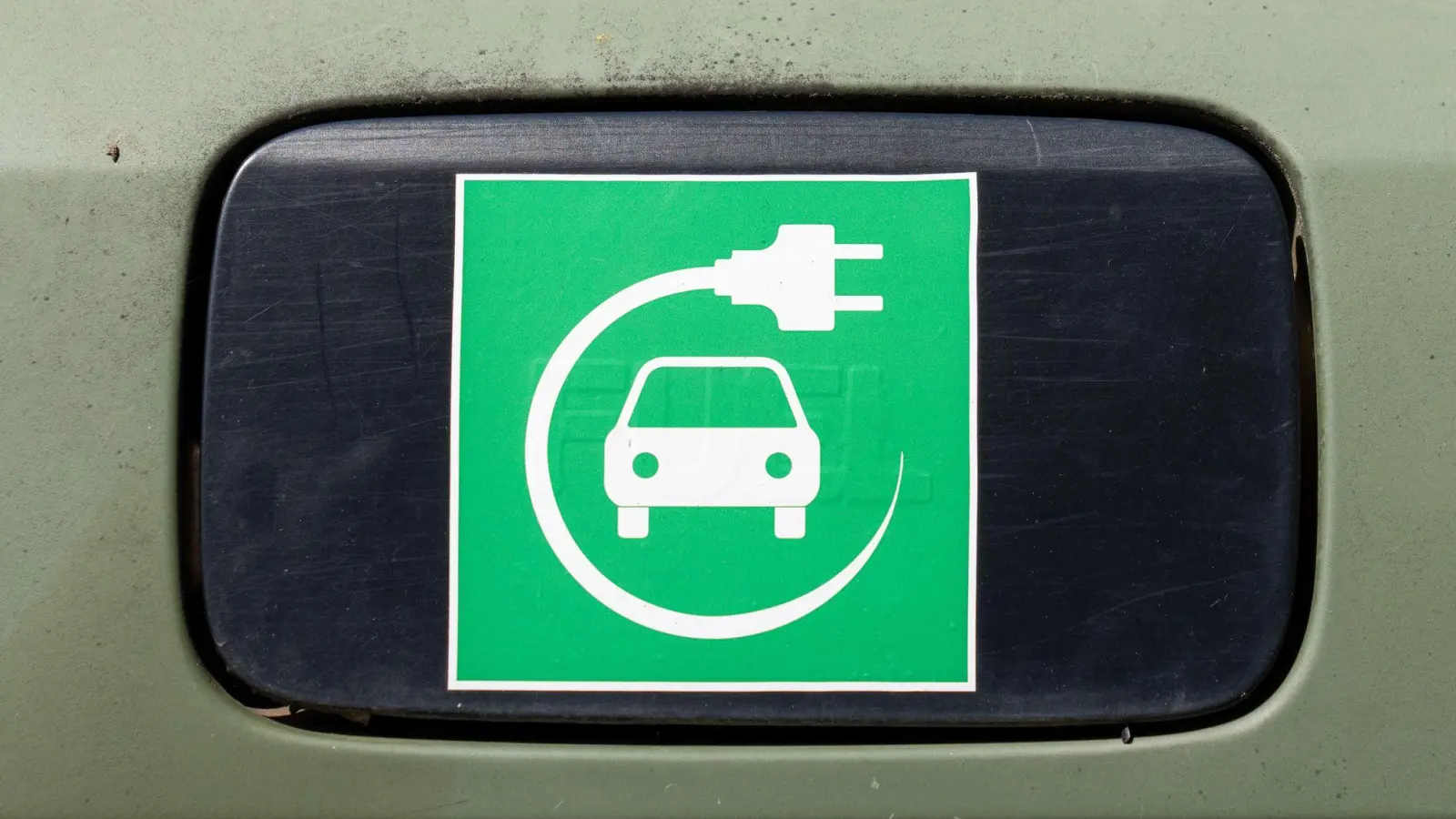 Ein Elektroauto-Symbol auf einem Auto.  (Foto: Soeren Stache/dpa)