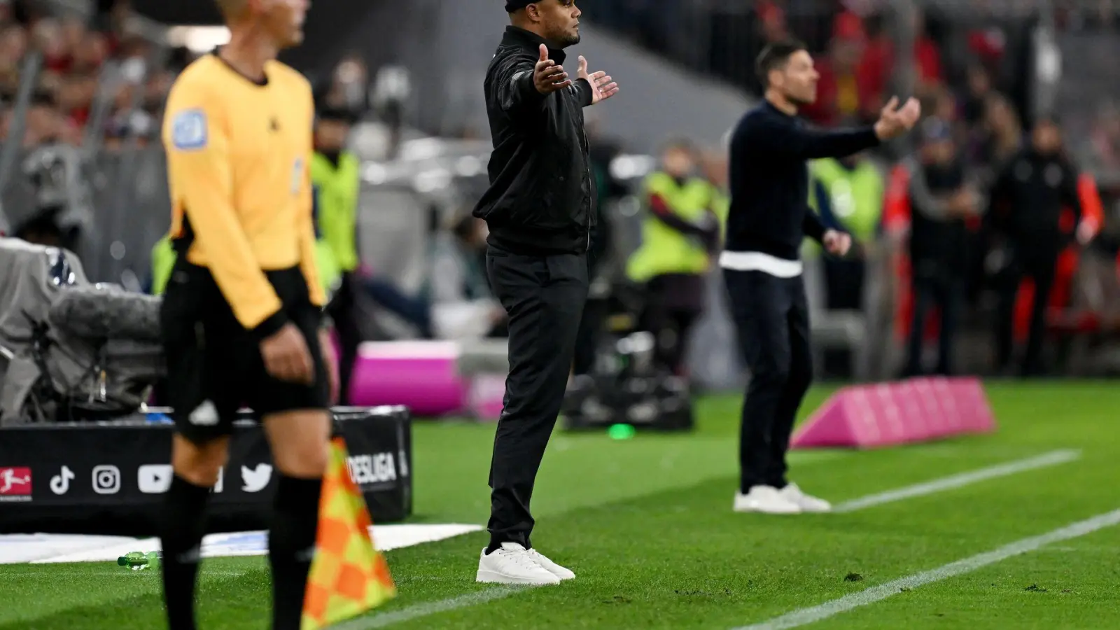 Schnelles Wiedersehen am Spielfeldrand: Bayern-Coach Vincent Kompany (M) und Leverkusens Meistertrainer Xabi Alonso (r). (Foto: Sven Hoppe/dpa)