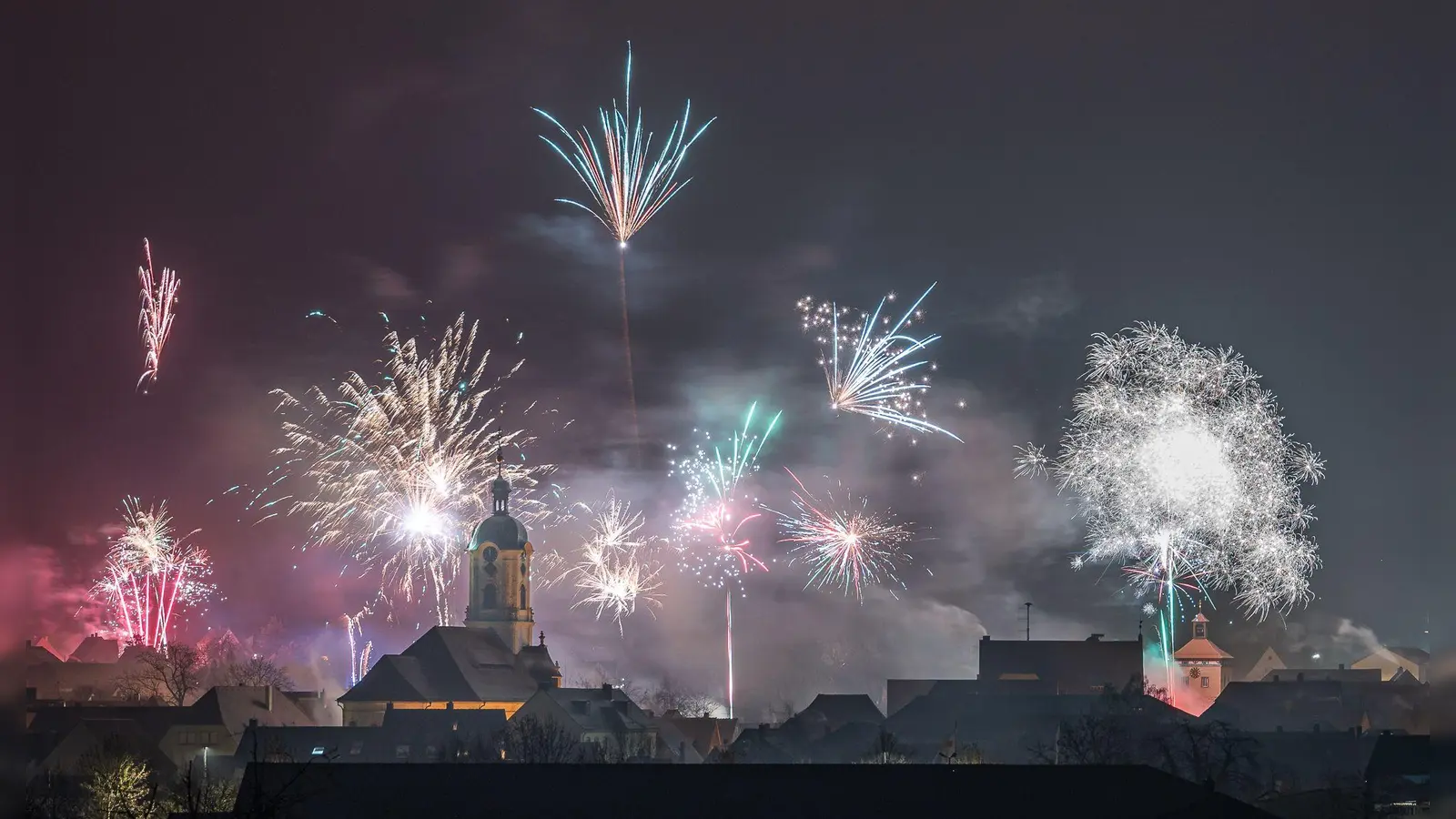 Feuerwerk über der Stadt Scheinfeld mit Blick auf die Stadtpfarrkirche Mariä Himmelfahrt und rechts den Torbogen. (Foto: Mirko Fryska)