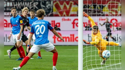 Union Berlins Tom Rothe (2. v l) trifft zum 0:2 gegen Kiels Torwart Timon Weiner (r). (Foto: Axel Heimken/dpa)