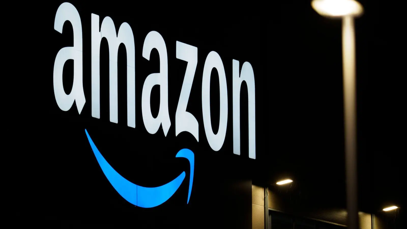 Das Logo von Amazon an einem Logistikzentrum: Die EU-Kommission hat nach jahrelangem Streit Zugeständnisse des weltweit größten Online-Händlers akzeptiert. (Foto: Soeren Stache/dpa-Zentralbild/dpa)