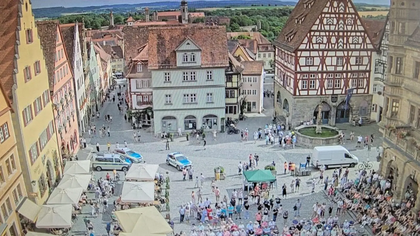 Ein Screenshot einer Webcam, die an der Ratstrinkstube installiert ist, zeigt die Szenerie: Im Vordergrund sitzt das Publikum des Konzertes. Die Versammlung der Friedensinitiative fand rund um den grünen Pavillon statt. (Foto: Screenshot der Webcam an der Ratstrinkstube)