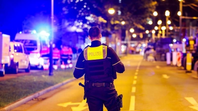 Ein Polizist sichert den Bereich vor dem Mulitplex-Kino. (Foto: Christoph Reichwein/dpa)