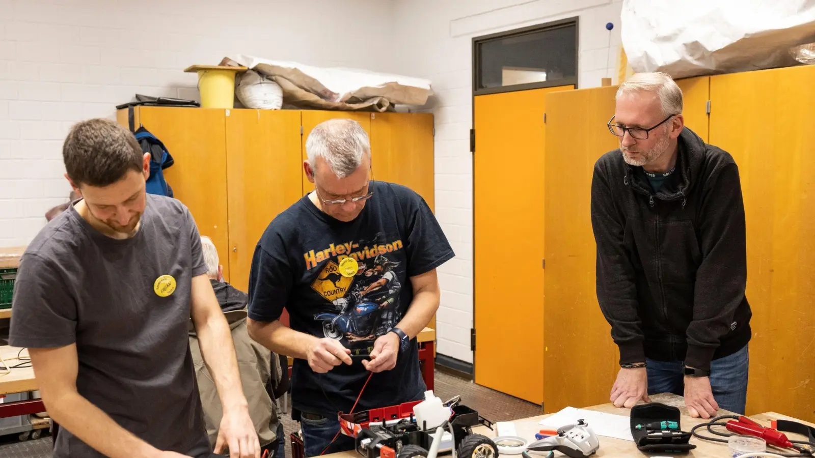 Fabian Knauf (l-r) und Patric Hilgert reparieren von Michael Jarczyk mitgebrachten RC-Autos. Temporäre Selbsthilfewerkstätten sind zunehmend gefragt. (Foto: Hannes P. Albert/dpa)