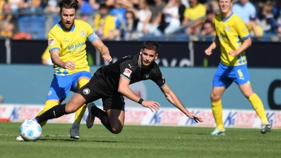 Der Fürther Nemanja Motika (Mitte) stolpert - wie sein ganzes Team - in Braunschweig. (Foto: Swen Pförtner/dpa)