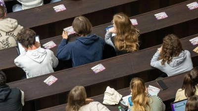 Studenten nehmen an der Einführungveranstaltung im Audimax der Ludwig-Maximilians-Universität teil. (Foto: Peter Kneffel/dpa)