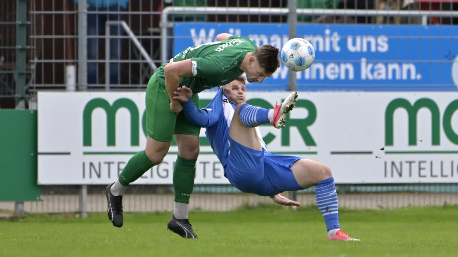 Mit Biss im Zweikampf: Gegen Illertissen (im blauen Trikot Tobias Rühle) blieb Ansbach mit Verteidiger Jonas Bayerlein (links) erstmals in dieser Saison ohne Gegentor. (Foto: Martin Rügner)