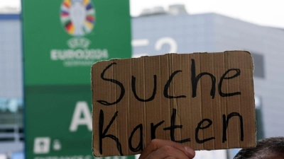 Ein Fan hält ein Schild mit der Aufschrift „Suche Karten” hoch, um doch noch irgendwie an Eintrittskarten für ein Spiel zu kommen. (Foto: Marcus Brandt/dpa)