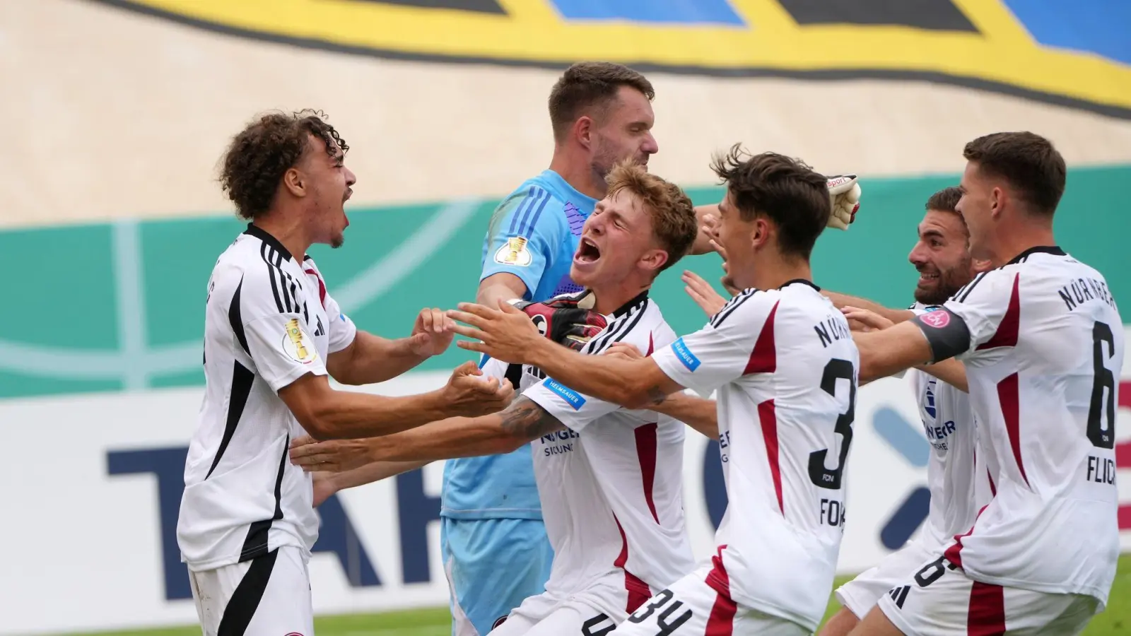 Darf sich feiern lassen: Nürnbergs Torwart Christian Mathenia (blaues Trikot). (Foto: Thomas Frey/dpa)