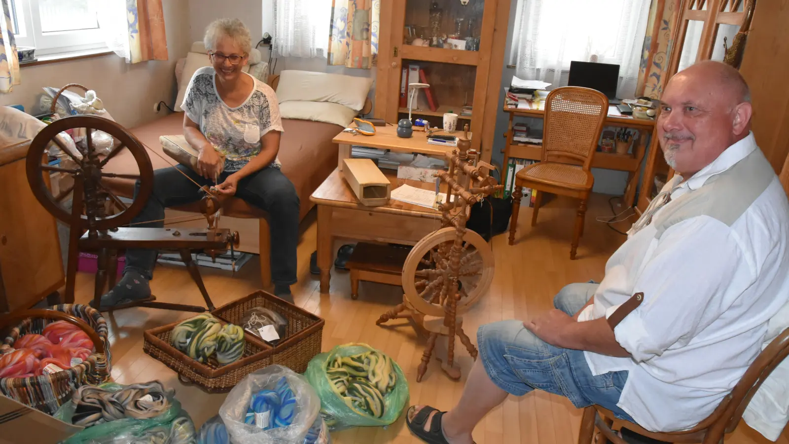 Bei Sibylle und Gerhard Haager dreht sich vieles am und um das Spinnrad. Die alte Wollmachkunst gibt ihnen viel Ruhe. Gerhard Haager unterstützt seine Gattin bei der Reparatur der Geräte und mit Ersatzteil-Erfindungen, darunter das inzwischen patentierte Spinnfutteral vom Holz des Blauglockenbaumes in der Bildmitte. Aber hauptsächlich inspirieren die zahlreichen Spinnräder zum Schreiben von lustigen Liedtexten. (Foto: Anita Dlugoß)