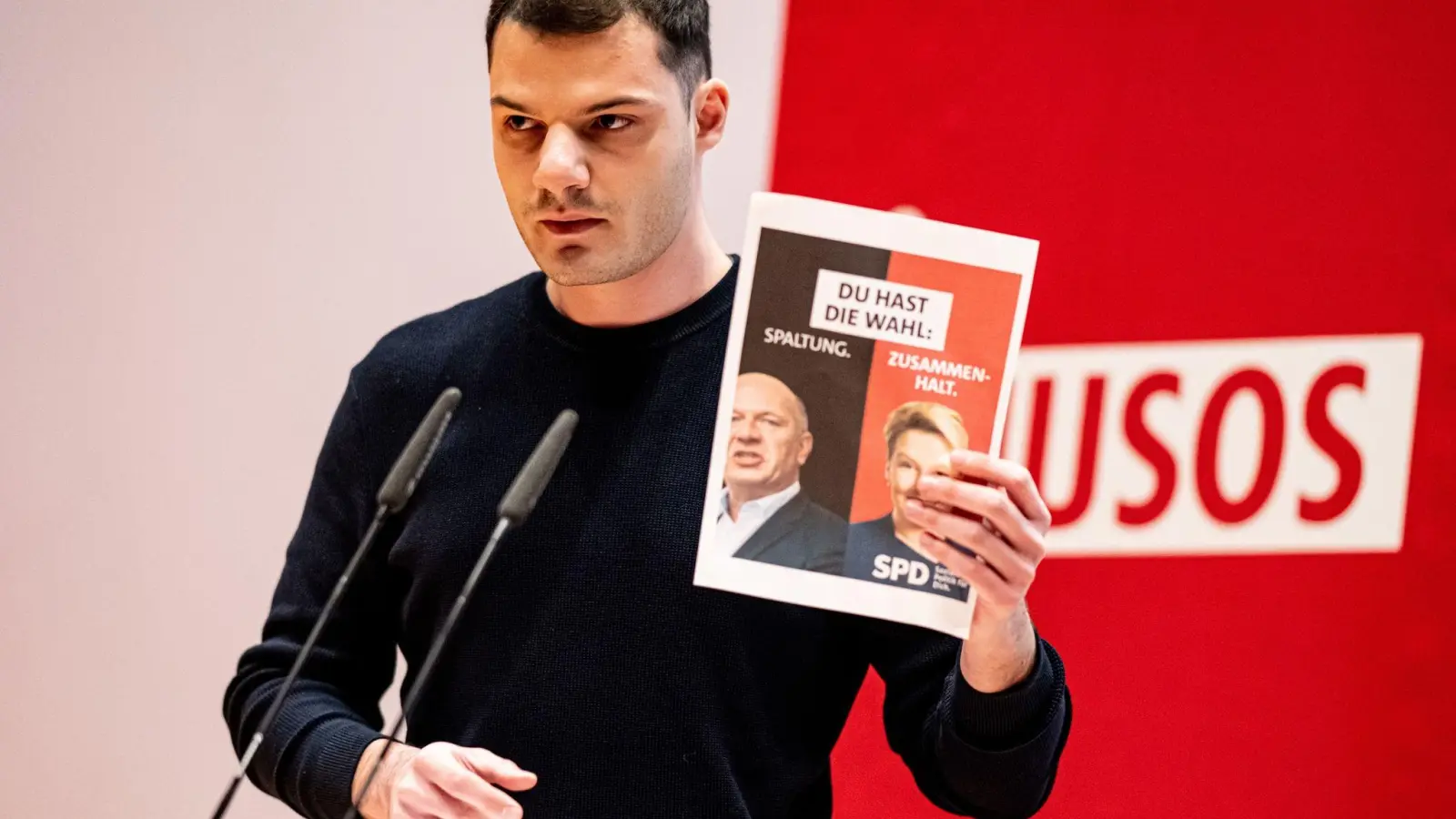 Kubilay Yalcin hält auf der Landesdelegiertenkonferenz der Jusos Berlin ein Wahlplakat mit Giffey und Wegner in die Höhe. (Foto: Fabian Sommer/dpa)