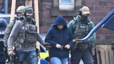 Die frühere RAF-Terroristin Daniela Klette wird nach einem Haftprüfungstermin beim Bundesgerichtshof von Polizisten zu einem Hubschrauber geführt. (Foto: Uli Deck/dpa)