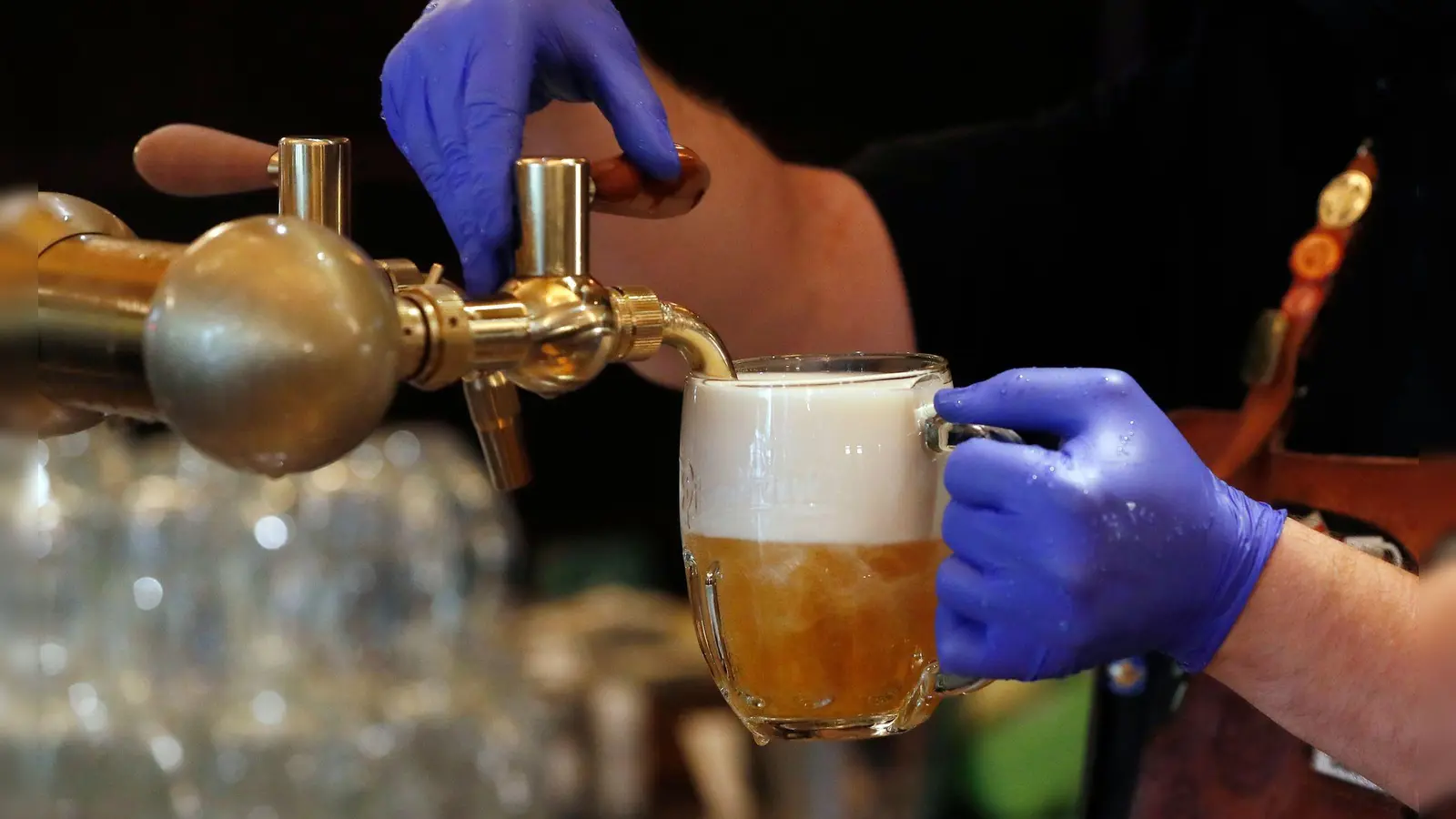 Ein Barkeeper zapft ein Bier auf einer Restaurant-Terrasse. (Symbolbild) (Foto: Petr David Josek/AP/dpa)