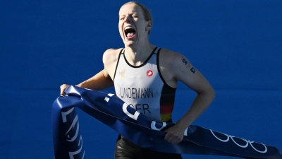 Laura Lindemann trägt bei der Schlussfeier der Olympischen Spiele gemeinsam mit Max Rendschmidt die deutsche Fahne. (Foto: Marijan Murat/dpa)