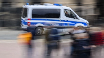 Ein Einsatzwagen der Polizei fährt durch eine Stadt. (Foto: Robert Michael/dpa/Symbolbild)