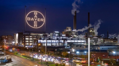 Das Bayer-Kreuz, das Logo des Unternehmens, leuchtet auf dem Werksgelände von Bayer in Leverkusen.  (Foto: Thomas Banneyer/dpa)