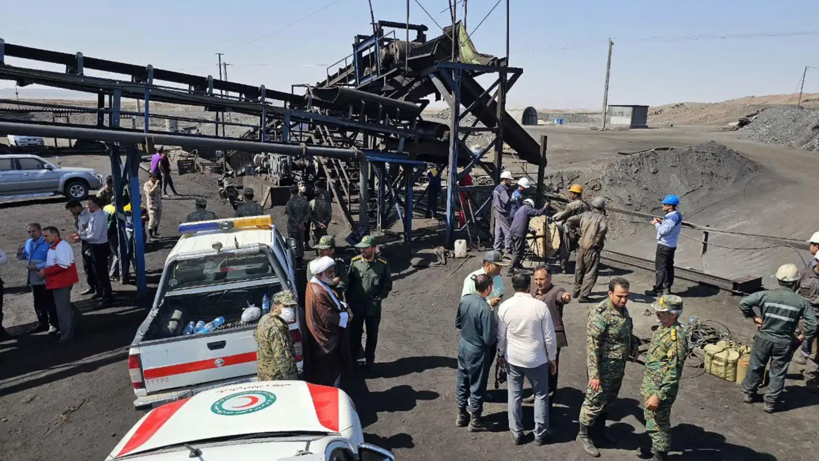 Bergleute und Polizisten am Standort der Kohlemine. (Foto: Uncredited/Iranian Red Crescent Society/AP/dpa)