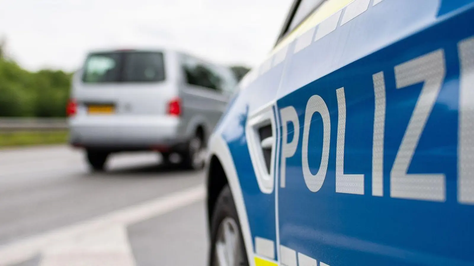 Ein Streifenwagen der Polizei steht auf einer Straße. (Foto: Guido Kirchner/dpa/Symbolbild)