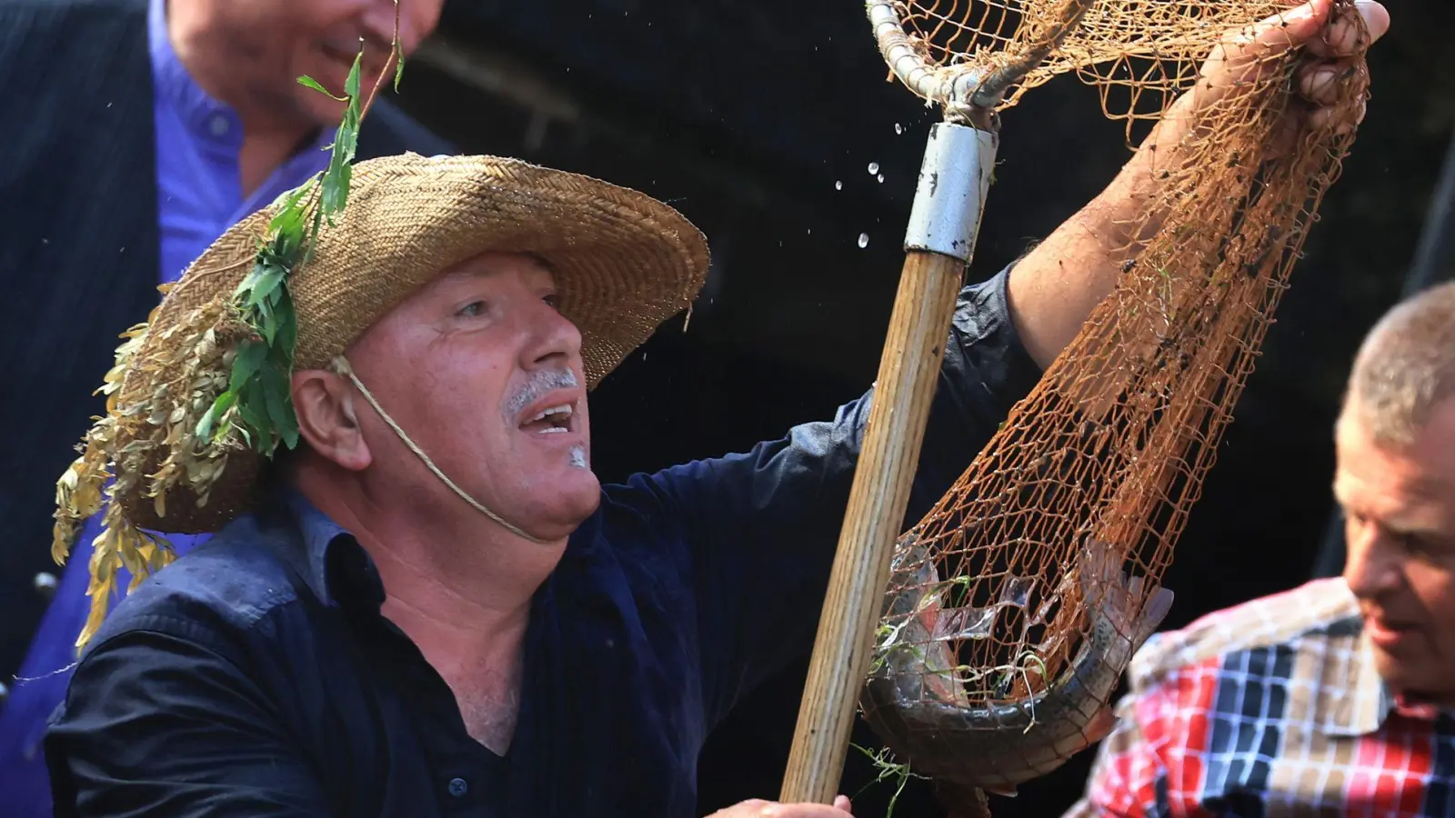 Ein Teilnehmer des Fischertages in Memmingen freut sich über eine gefangene Forelle. Tierschützer nutzten die Veranstaltung, um einmal mehr gegen das aus ihrer Sicht tierquälerische Brauchtum zu protestieren. (Foto: Karl-Josef Hildenbrand/dpa)