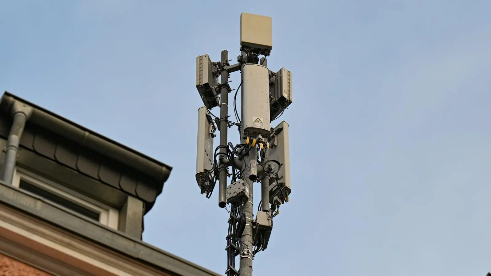 Ein Mobilfunkmast mit 4G/LTE-Antennen (länglich) und 5G-Antennen (quadratisch) steht auf einem Dach eines Wohnhauses. (Foto: Wolf von Dewitz/dpa)