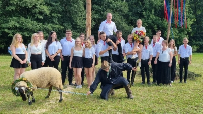 Von der Musik, die vom Festplatz herüberwehte, wurde Schaf Emma offenbar magisch angezogen, so dass Schäfer Ulrich Henschker just beim Gruppenfoto nach dem Betzentanz – die Sieger Sarah Wörlein und Alexander Sehring sind an ihrer erhöhten Positionierung leicht auszumachen – kurz das Gleichgewicht verlor. (Foto: Rainer Weiskirchen)