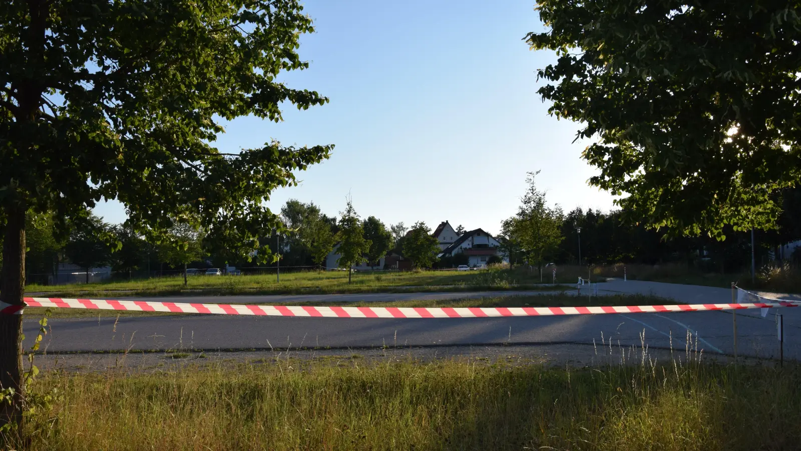 Auf einer Fläche zwischen Wohnbebauung und Sportpark soll der Neubau der Grund- und Mittelschule realisiert werden. Die Flatterbänder, die hier derzeit hängen, stammen von der Bürgerinitiative. Sie sollen die Ausmaße des Gebäudes zeigen. (Foto: Florian Schwab)