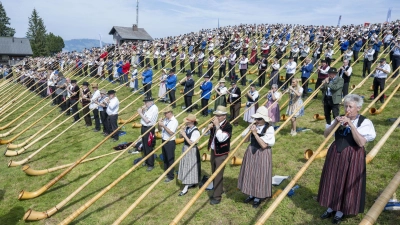 Die Alphornbläserinnen und -bläser standen dicht an dicht an einem Hang. (Foto: Urs Flueeler/KEYSTONE/dpa)