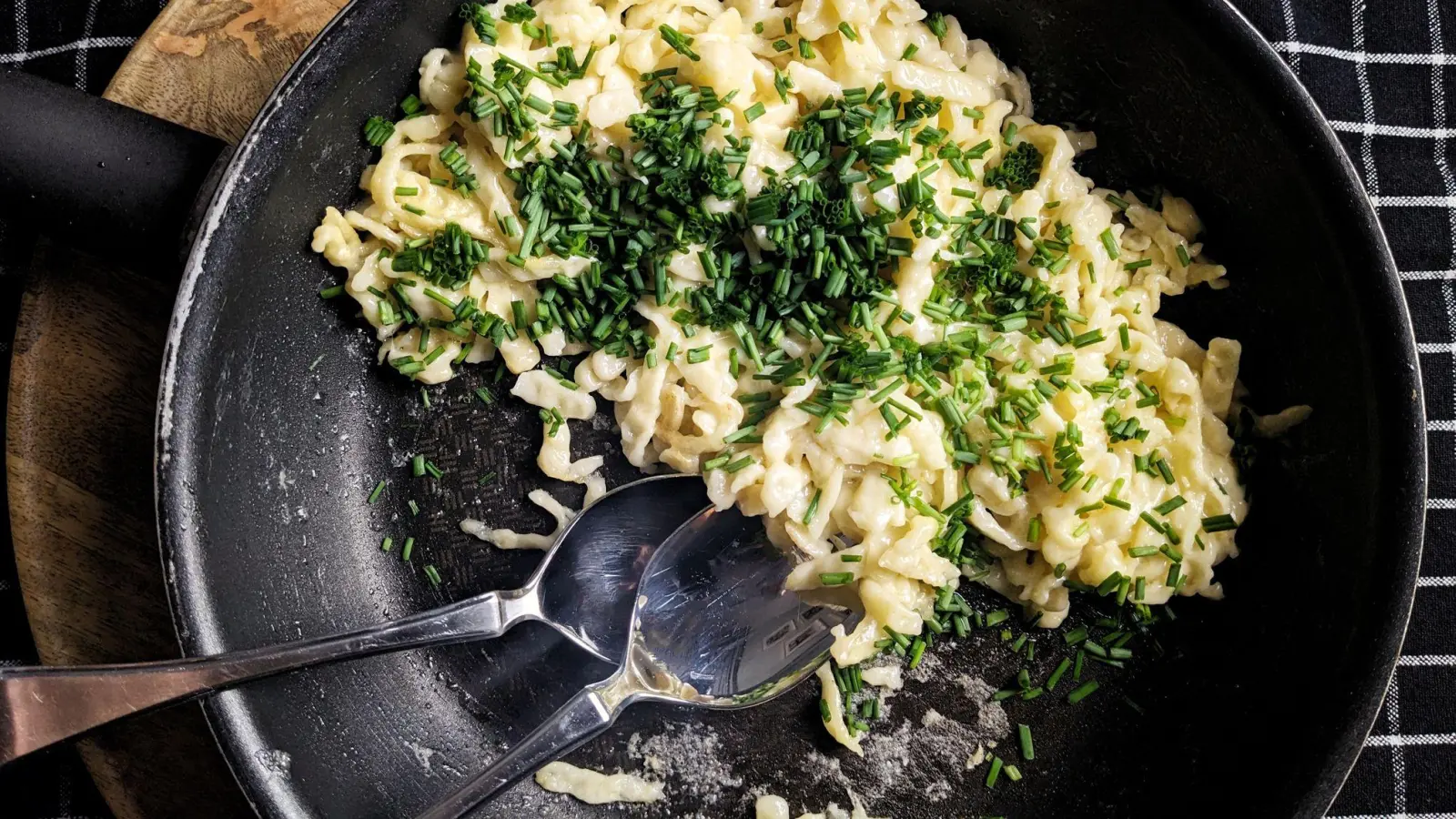 Für Kasnockerl kommen Spätzle und Käse auf den Herd und werden mit Schnittlauch bestreut - und das Ganze wird am besten direkt aus der Pfanne gegessen.  (Foto: Doreen Hassek/hauptstadtkueche.blogspot.com/dpa-tmn)