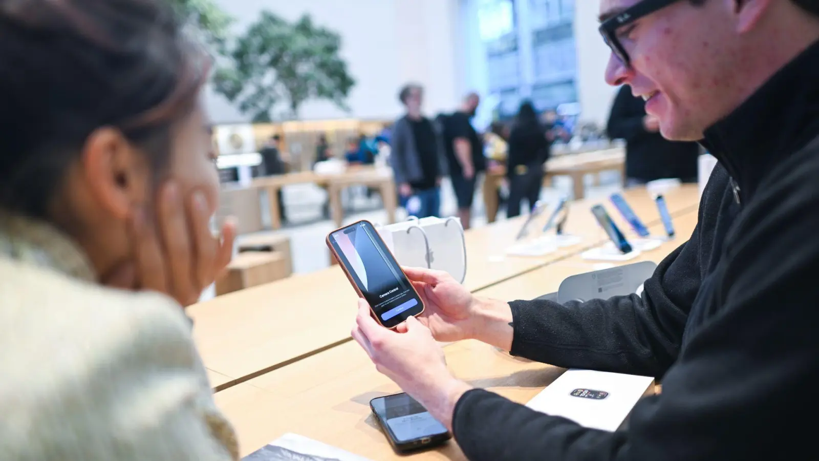 Dieser Mann ist einer der ersten Käufer des iPhone 16 in Deutschland. Gerade richtet er das Gerät im Apple Store in Berlin-Mitte ein. (Foto: Sebastian Christoph Gollnow/dpa)