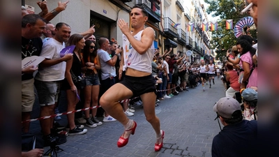 Mit großen Schritten rennt ein Teilnehmer des jährlichen High-Heels-Rennens während der Pride Week durch das Chueca-Viertel in Madrid. (Foto: Paul White/AP/dpa)