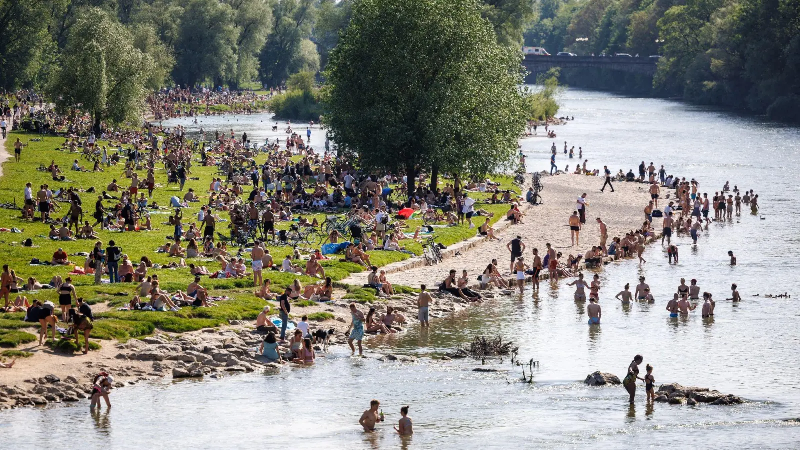 Nicht nur Badeseen sind beliebt zum Abkühlen an heißen Tagen, sondern auch Flüsse - wie hier die Isar in München. Doch gerade in der Mitte der Gewässer ist die Strömung oft stark. (Foto: Matthias Balk/dpa/dpa-tmn)